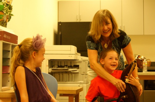 instructor helps girl try uillean pipes