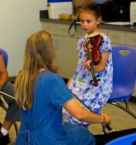 teacher helping fiddle student