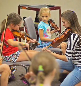 Hailey helping in fiddle class